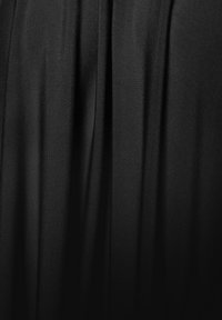 Juodas drapiruotas audinys su lygiu paviršiumi, demonstruojantis švelnias klostes ir subtilų blizgesį. Medžiaga atrodo lengva ir laisvai krintanti.