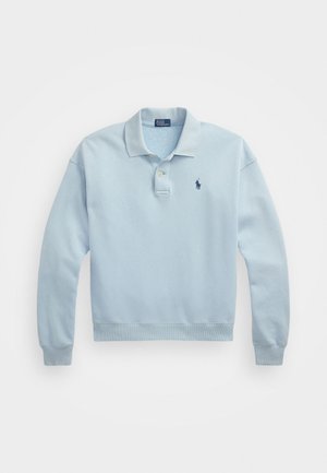 Svetlo modrý bavlnený polo sveter s dlhými rukávmi, s dvomi gombíkmi a malým vyšitým logom v námorníckej modrej na hrudi. Mäkká textúra.