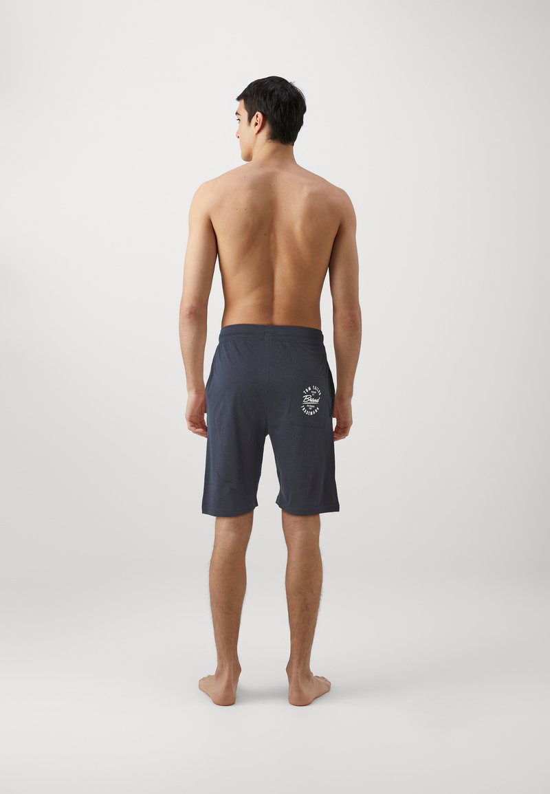 Shorts de bain pour hommes gris foncé avec un motif uni, ceinture élastique et détail de logo sur la poche arrière. Fabriqués en tissu léger.