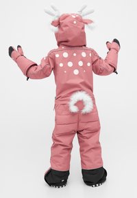 Roze kinder sneeuwpak met cirkelvormige witte patronen, bontaccenten op de capuchon en staart, en zwarte manchetten aan de benen.