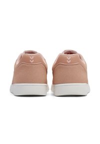 Rosa semskede joggesko med teksturert finish, hvit gummisåle og en liten logo på hælen med tre oppadgående piler.