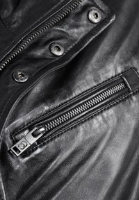 Zwart leren jack met een close-up van een ritszak en zilveren hardware. De textuur is glad met zichtbare naaddetails.