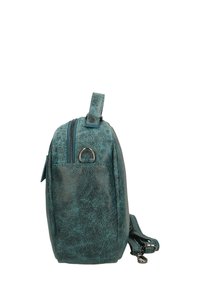 Borsa in ecopelle turchese con finitura testurizzata, chiusura con zip, manico laterale e tracolla regolabile. Design compatto con forma arrotondata.