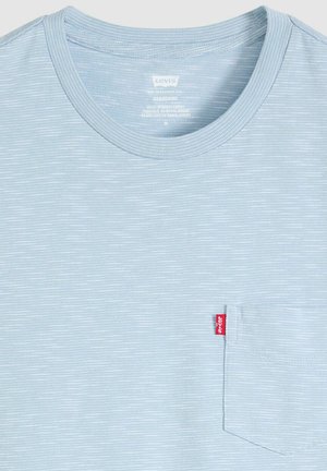 Maglietta a righe sottili azzurro chiaro e bianco con una piccola tasca sul petto a sinistra e una targhetta con il logo Levi's rossa.
