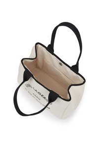 Plátená taška v krémovej farbe s čiernymi akcentmi na rúčkach. Obsahuje potlačené logo a priestranný interiér s bočnou vreckom a zacvakávacím uzáverom.