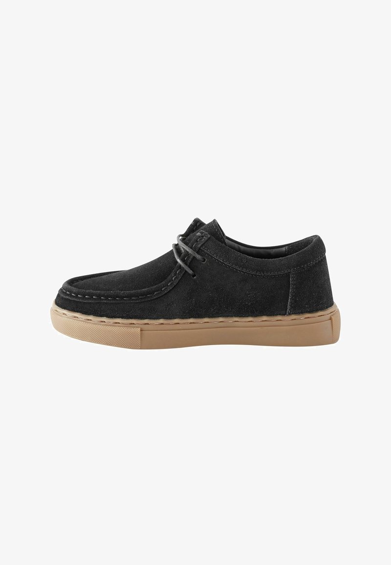 Chaussure décontractée en daim noir avec design moc toe, semelle en caoutchouc beige et lacets noirs assortis, vue de côté sur fond blanc.