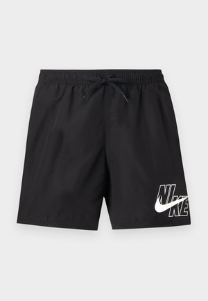 Melni Nike peldēšanas šorti ar elastīgu jostu, auklu un baltu logotipu uz kreisās apakšējās kājas vienkārša fona priekšā.