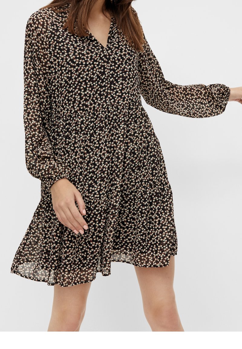 Robe noire à fleurs avec manches longues, col en V et coupe ample. Présente de petits motifs floraux multicolores et un tissu léger texturé.