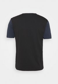 Camiseta negra de manga corta, con un acento azul oscuro en los hombros, confeccionada con una suave mezcla de algodón.