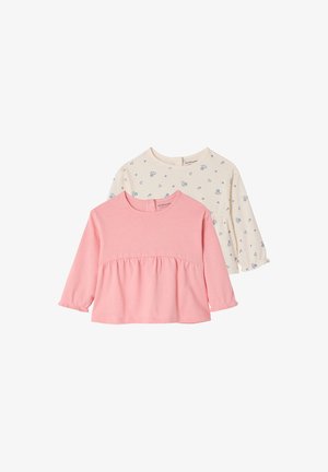 Two long-sleeve toddler tops, one solid pink with gathered waist, one cream with small blue floral and heart prints.