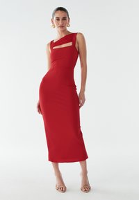 Rød midi-kjole med asymmetrisk halsudskæring, der har plisserede skulderstropper og udskæringsdetalje. Glat tekstur, tætsiddende silhuet og elegant design.