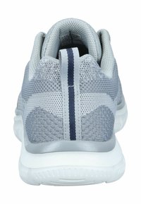 Baskets de sport gris clair avec un tissu en maille, un onglet de traction vertical foncé à l'arrière, et une semelle texturée blanche, vues de l'arrière.