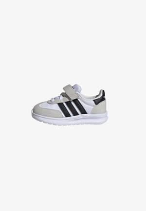 Sneaker grigio, bianco e nero realizzato in materiali scamosciati e in rete, con cinturino in velcro e tre strisce nere sui lati. Presenta una suola testurizzata.