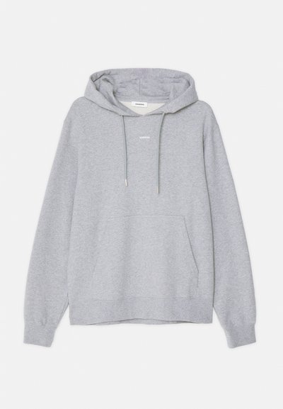 Haut en coton gris clair avec une poche kangourou à l'avant, une capuche à cordon, des poignets côtelés et un petit logo "Sandro" sur la poitrine ainsi qu'une étiquette à l'intérieur du cou.