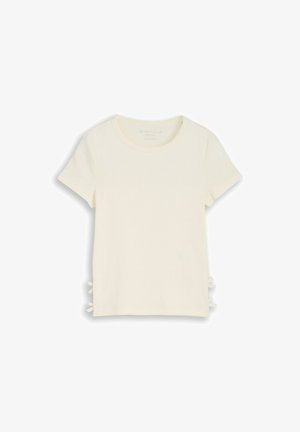 Camiseta crema de manga corta con escote redondo y detalles de lazos a los lados en ambas partes.