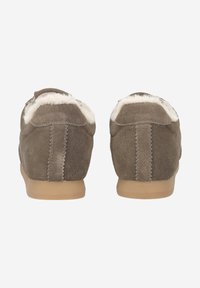 Chaussons en daim marron avec une semelle en caoutchouc beige, dotés d'une doublure en fausse fourrure couleur crème et de coutures décoratives le long du talon.