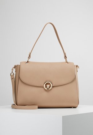 Sac à main en cuir beige avec poignée supérieure, rabat avant, fermoir rond doré et bandoulière détachable sur un socle blanc sur fond uni.