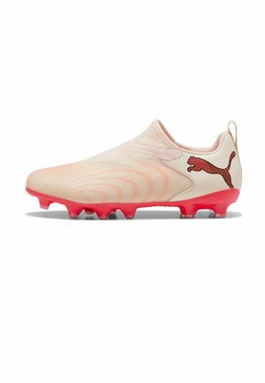 Lyse beige fodboldstøvler med koralrøde knopper og Puma-logo på hælen, med tekstureret overdel og træktab på bagsiden.