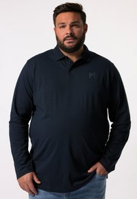 Mörkblå långärmad polo med krage, med en diskret logotyp på bröstet, tillverkad av ett mjukt tyg.