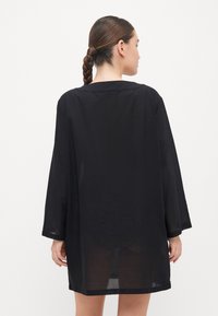 Čierny priesvitný kimono štýlu, voľný strih, dlhé rukávy, rovný lem, jemná textúra, jednoduchý dizajn, dĺžka po kolená, bez podšívky.