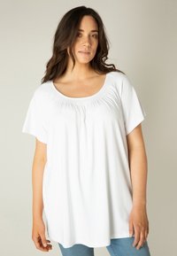 Witte korte mouwen top met een ronde hals, voorzien van geplooide details op de borst, gemaakt van zachte, gladde stof.