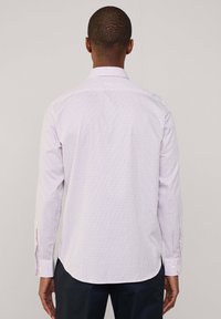 Camicia a maniche lunghe di un leggero lavanda con un motivo a scacchi in viola e rosso. Collo classico, polsini con bottoncini, orlo curvo. Tessuto in misto cotone.