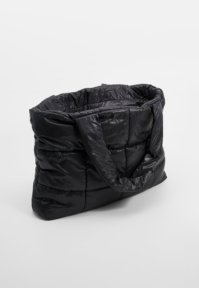 Schwarze Puffer-Tote-Tasche mit gestepptem Design, zwei stabilen Griffen und einer weichen, glänzenden Textur. Große Öffnung für einfachen Zugang zu den Inhalten.