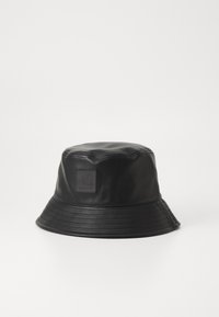 Pălărie din piele neagră în stil bucket, cu un patch pătrat cu logo, având o margine largă și evazată și detalii striate în jurul bazei pentru textură.