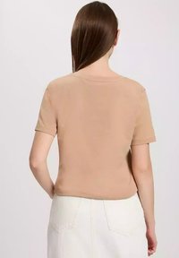 Krótki rękaw t-shirt w kolorze brązowym, wykonany z miękkiej bawełny, z okrągłym dekoltem i gładką fakturą, z prostym cięciem na dole.