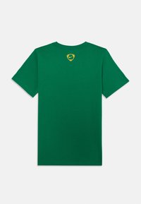 Zaļš kokvilnas T-krekls ar īsām piedurknēm, ar mazu dzeltenu un melnu logotipu augšējā muguras daļā. Klasisks apaļas kakla dizains.