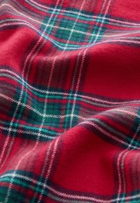 Červená károvaná tkanina s vzorom zelených a bielych pruhov. Mäkká textúra s brúseným povrchom, vhodná na oblečenie alebo deky.