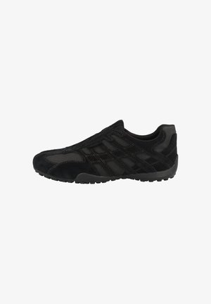 Zapatillas deportivas negras con parte superior de ante y paneles de malla, forma curva, suela texturizada y detalles de costura en contraste.