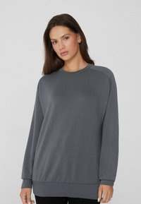Grauer Langarm-Sweatshirt mit Rundhalsausschnitt, entspannter Passform und gerippten Bündchen sowie Saum. Glatte Textur, minimalistisches Design.