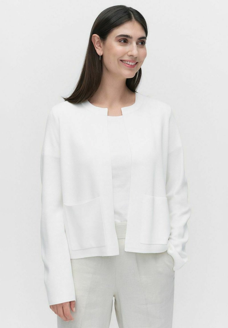 Witte cardigan van zacht materiaal, met een ronde halslijn, open voorkant, lange mouwen en twee voorzakken.
