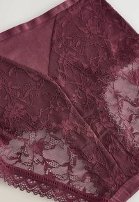 Burgundy spetsunderkläder med blommönster, en slät satinmidja och vågiga kanter för extra textur och detaljer.