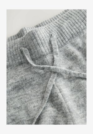 Halli kudumaterjal, millel on soonik, mis on varustatud nööridega. Tekstuur on pehme ja sellel on õrn hallikatähniline muster.