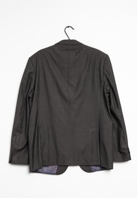 Giacca da completo da uomo grigio scuro appesa a un appendiabiti nero, vista da dietro, con un sottile motivo a quadri e una fodera viola visibile all'orlo.
