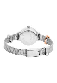 Reloj con correa de malla plateada, con caja redonda, corona visible y un acento en oro rosado en el cierre. Presenta una textura suave de acero inoxidable.