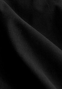 Tissu noir au toucher lisse et mat. De subtiles plis et ondulations créent une apparence en couches, mettant en valeur sa nature douce et flexible.