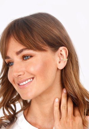 Goldene Ohrcuff mit geschwungenem Design und einer Reihe kleiner, klarer Steine, die einen eleganten und modernen Look auf der Haut präsentieren.