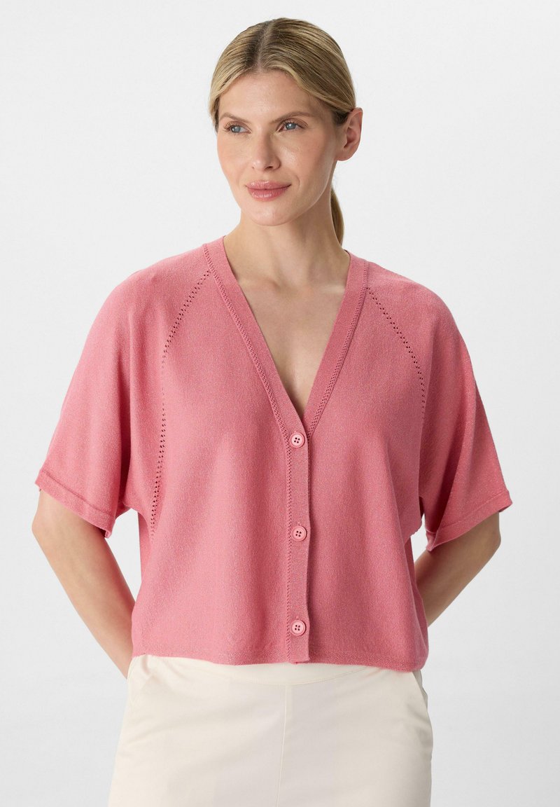 Rosa kurzärmlige Strickjacke mit V-Ausschnitt, fünf Knopfverschluss und strukturiertem Strick, mit Lochmuster entlang der Schultern.