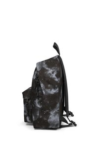 Mochila negra con un estampado de galaxia nublada en tonos grises y blancos, con correas ajustables y un bolsillo frontal con cremallera. Vista lateral.