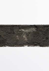 Sort sequin-stof med overlappende cirkulære paljetter i forskellige størrelser, hvilket skaber en tekstureret, glitrende overflade med subtile farvevariationer.