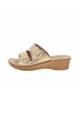 Sandalo con zeppe beige e oro con due cinturini regolabili con ritagli decorativi rotondi e suola marrone texturizzata.