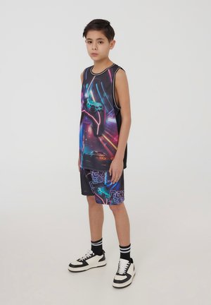 Completo sportivo senza maniche di colore nero con una vivace grafica di un controller di gioco, accenti al neon e pantaloni corti coordinati con testo viola.
