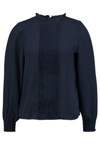 Blouse bleu marine à manches longues avec un col montant à volants, des plis verticaux au centre et des poignets smockés. Tissu lisse et léger.