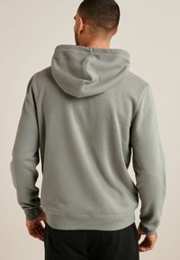 Grau Hoodie mit einer glatten Textur, einer Kapuze mit Kordelzug und gerippten Bündchen und Saum. Die Rückseite ist schlicht ohne zusätzliche Muster oder Details.