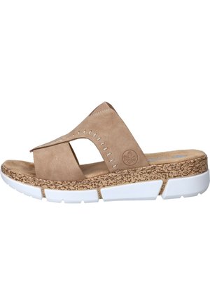 Beige open teen slidesandaal met gekruiste bandjes, gestructureerde kurkstijlzool, witte gesegmenteerde buitenzool en decoratieve stiksels op de bandjes.