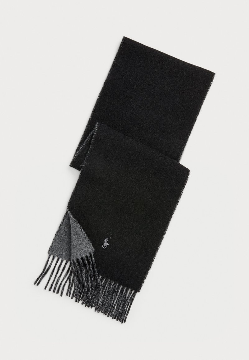 Sort og mørkegrå uldscarf med frynser i enderne og et lille broderet logo nær en af frynserne.