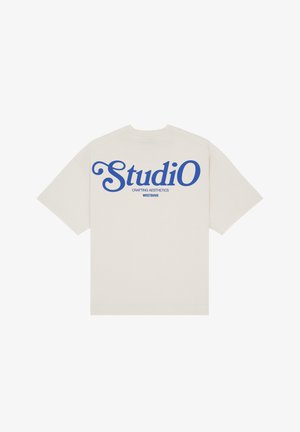 Beżowy T-shirt z krótkim rękawem z niebieskim napisem „StudiO”, „Crafting Aesthetics” i „WRSTBHVR” na plecach, pokazany rozłożony na białym tle.